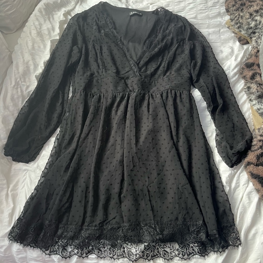 Black mini dress with polka dot and lace details and a deep V neck.